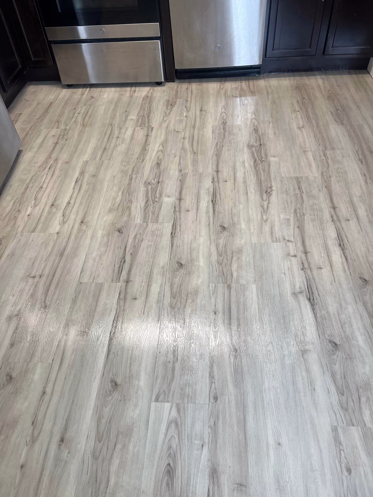 Kitchen floor deep cleaning after showing restored clean vinyl planks in a kitchen